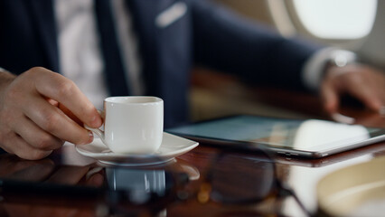 Fototapeta na wymiar Man enjoying coffee beverage on business trip. Closeup hand taking tea cup