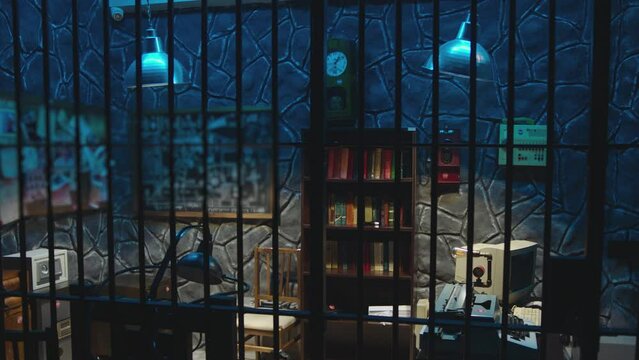 Dark jail cell at night . Hanging Swaying swinging lamps on dark room . Silhouette of policeman opening Interrogation room before interrogating . Prison life concept . Shot on camera ARRI slow motion