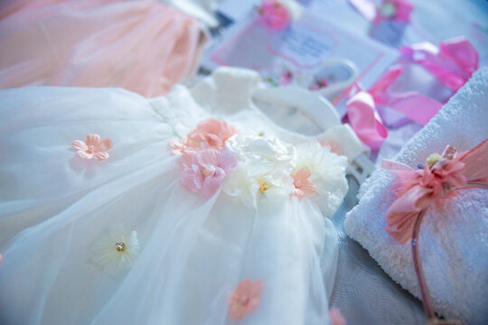 Baptism pictures. White gown baby with pink flowers outfit for religious celebration after birth. High quality photo