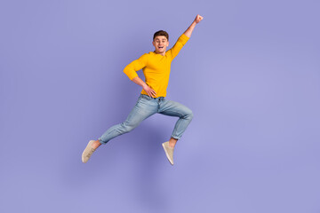 Fototapeta na wymiar Full body profile side photo of young man jump up fly protection power superhero isolated over violet color background