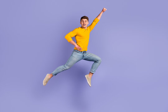 Full body profile side photo of young man jump up fly protection power superhero isolated over violet color background