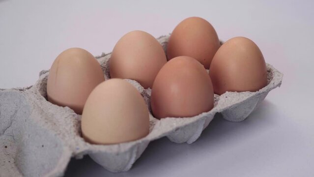 Chicken brown fresh raw eggs in a paper box. An egg carton with six eggs. Lots of fresh raw chicken eggs.