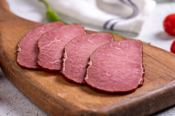 Beef jerky pieces. Sliced pieces of dry meat on a stone floor. close up