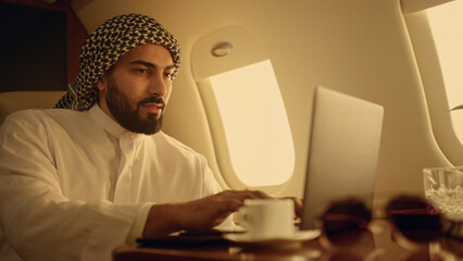 Positive ceo typing laptop on business trip closeup. Smiling arabian enjoying
