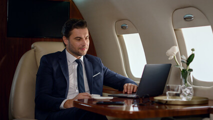 Focused businessman looking computer on corporate trip. Wealthy man work laptop