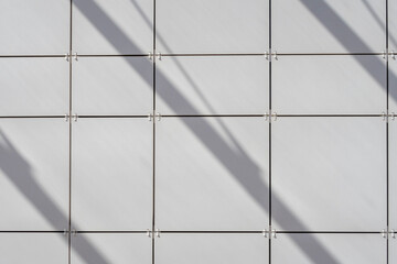 White tile surface with diagonal shadows. Geometric background image
