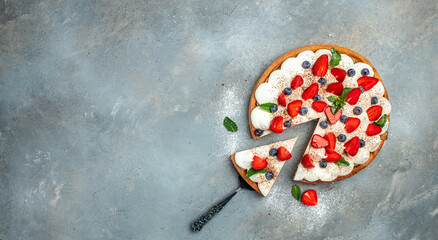 Delicious cake pie tart with fresh strawberries, raspberries, blueberry on gray background. Long banner format. top view