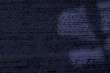 Fototapeta na wymiar Old brick wall with abstract light shape at dark evening time. Blue background image with copy space