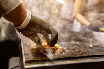 Hamburger buns toasting face down on a hot grill.