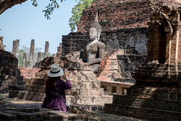 Traveler woman take image at Sukhothai historical park in Thailand.