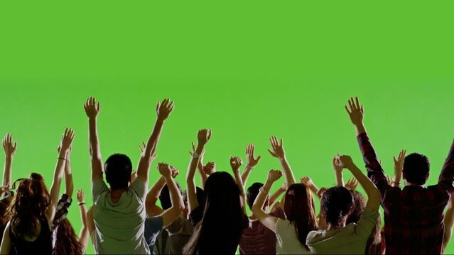 Group of young people or fans dancing , jumping and having fun on green screen. You can install different backgrounds of public place , concert stadium , disco clubs . Shot on RED camera . slow motion