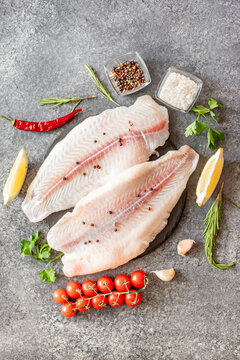 Fresh Raw White Fish Fillet Pangasius With Spices And Lemon On A Stone Background.