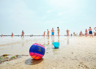 Beach volley ball on an Italian beach on a sunny summer morning with people in the back as they...