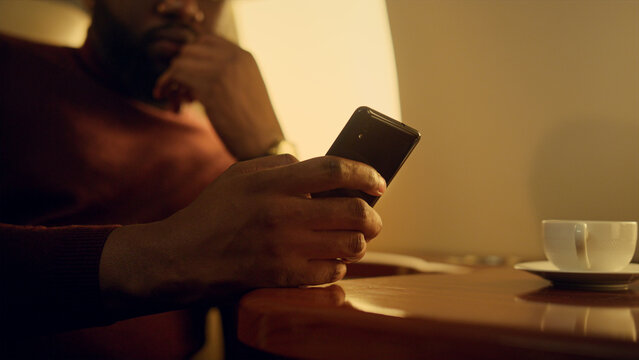 Focused businessman checking smartphone email. Hands holding cell phone closeup.