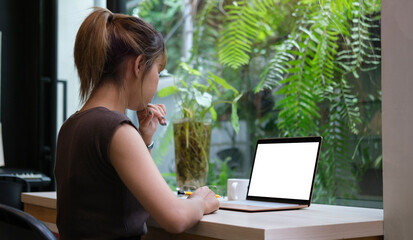 Woman working from home on laptop while sitting at the living room..