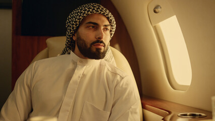 Closeup young arabian looking camera in muslim clothing. Smiling man rest at jet