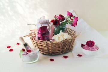 Obraz na płótnie Canvas Fresh pink and purple roses, water and sea salt with flower petals, on a light background, natural cosmetics, body care, love emotion
