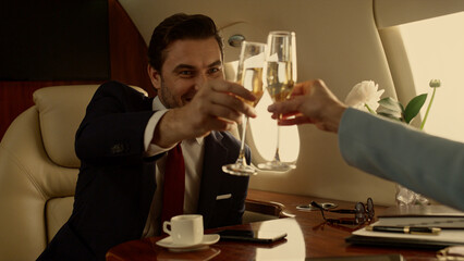 Business people shaking hands on private jet closeup. Corporate team celebrating