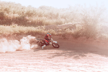 Live shot of male sportsman training on motorbike at hot summer day, outdoors. Motocross rider in...