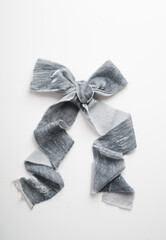 Grey bow made of velvet decorative colored ribbon on a white background. Wedding decor