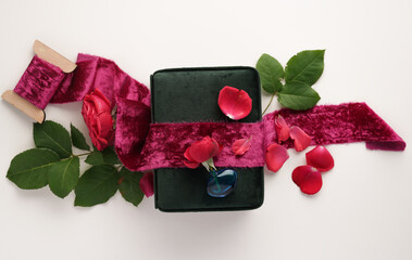 Composition with painted red, velvet ribbon and red rose, on the background of a jewelry box, top...