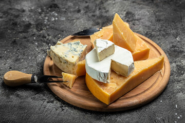 Parmesan. Different types of cheese with knife on a dark background. Cheeses set dor blu chedar...