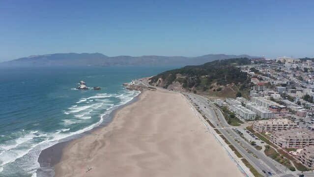 Aerial shot flying over Ocean Beach towards Land's End in San Francisco. 4K