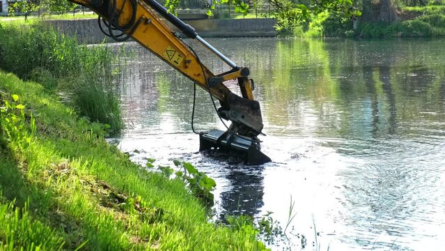 Industrial Heavy Duty Excavator Dredging River Bottom Removing Stincky Silt Mud Slime and Seaweed Wrack