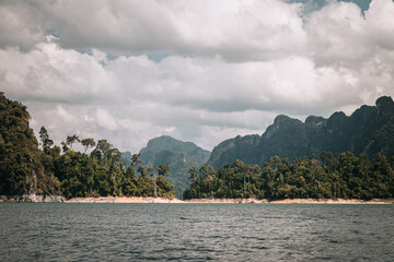 Obraz premium Khao Sok, Thailand - December 20th, 2019 : cliffs on the banks of the lake in the Thai national park of Khao Sok