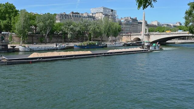 France, Paris, June 2022. A large barge carries sand along the Seine.