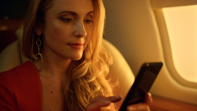 Joyful businesswoman chat smartphone in sunlight closeup. Business travel on jet