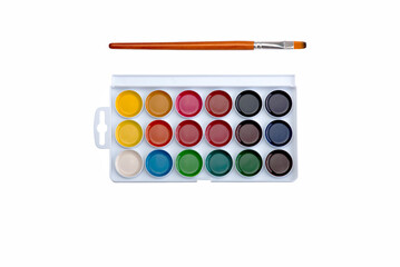 Multicolored aquarelle paints in paint box with brushes on white background.