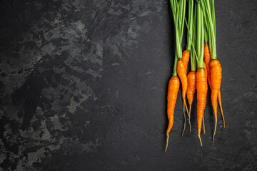 Fresh and sweet carrot bunch on dark background. Healthy vegan vegetable food. banner, menu, recipe place for text, top view