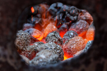 Glimmering heat from glowing charcoal to harden knives