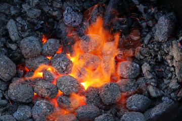 Glimmering heat from glowing charcoal to harden knives