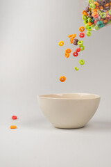Colorful cereal box for morning breakfast. Corn flakes falling to the white bowl. Motion.