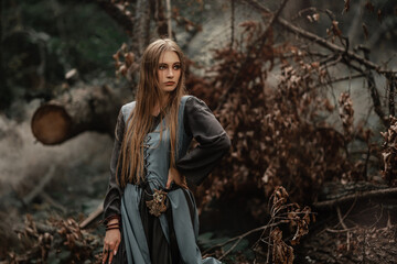 A mysterious witch walks in a dark forest