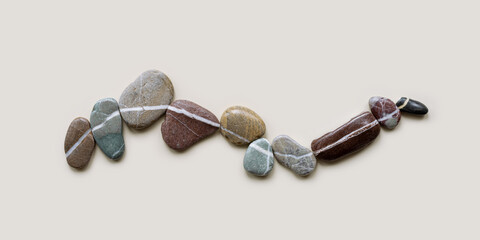 Top view still life with close-up sea stones on sand background, pebbles united by one row as wave. Row from natural stone. Minimal style flat lay, concept of calm, peace, meditation © yrabota