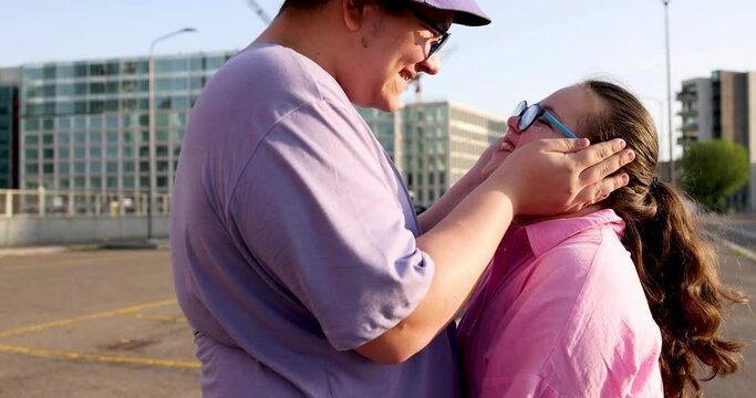Happy brother and sister kissing and embracing in the street