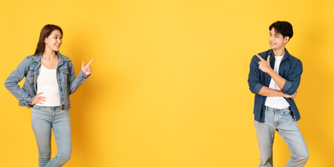 Two Young good looking asian couple using isolated on yellow background presenting to copy space
