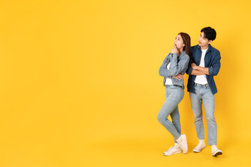 Fototapeta na wymiar Two Young good looking asian couple using isolated on yellow background presenting to copy space feeling excited