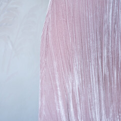 Texture velvet pink women's dress. Fragment against the background of a gray wall. High quality photo