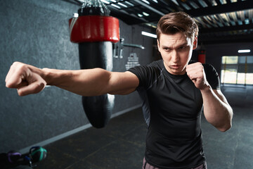 Professional sportsman shadow-boxing during gym training session - obrazy, fototapety, plakaty