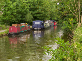 Fototapeta na wymiar Boats moored for the night just below Hirst Lock on a favourite stretch of the Leeds and Liverpool Canal for visitors to the World Heritage Site of Saltaire