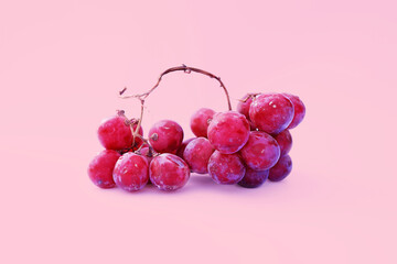 Big bunch of red grapes with 3 parts on pink background       