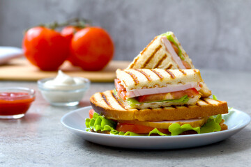 a stack of delicious grilled sandwiches with tomatoes, ham, sheese and fresh lettuce