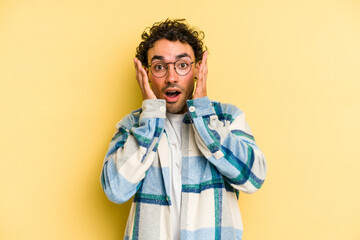 Young caucasian man isolated on yellow background surprised and shocked.