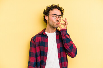 Young caucasian man isolated on yellow background with fingers on lips keeping a secret.