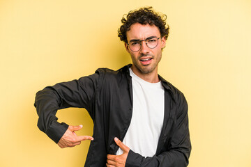 Young caucasian man isolated on yellow background having a liver pain, stomach ache.