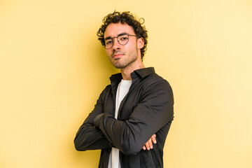 Young caucasian man isolated on yellow background unhappy looking in camera with sarcastic...